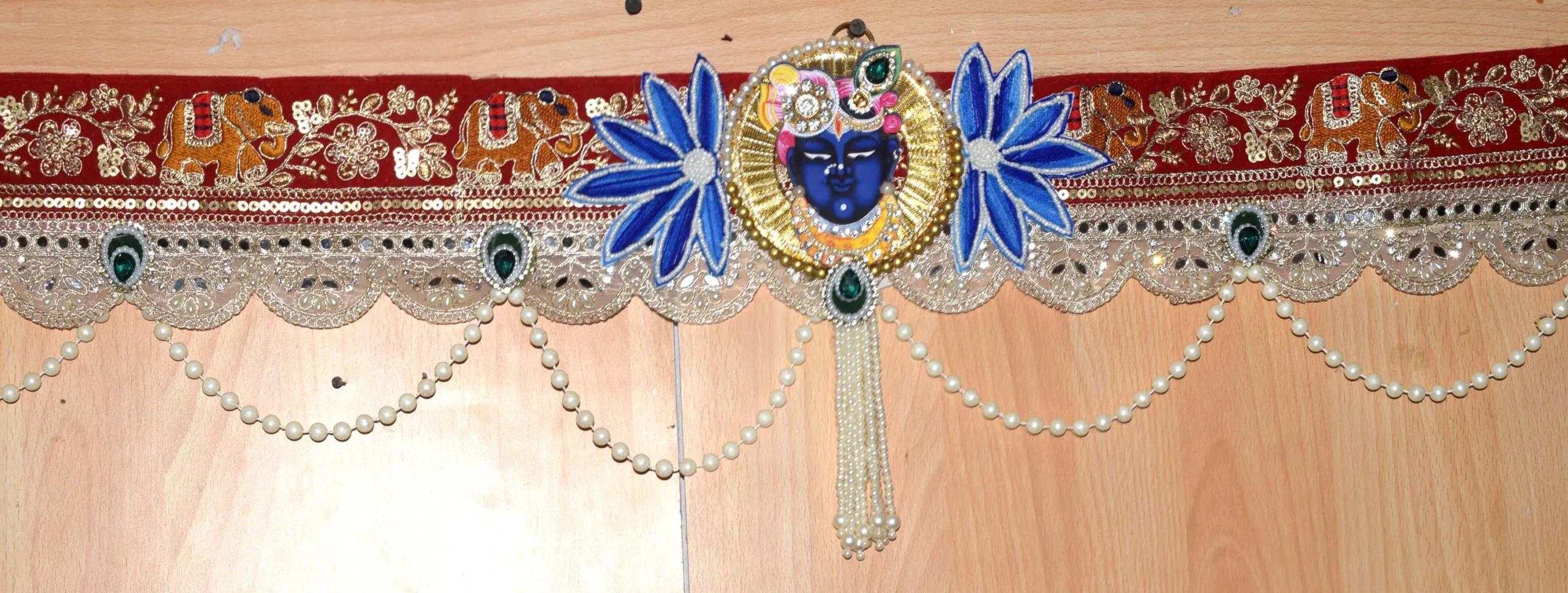 Premium handmade Krishna peacock embroidered toran with elephant motifs, kundan stone work, lace border, pearl tassels and decorative beads for main door and mandir decoration 43x13 inch Image Caption